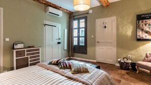 Un dormitorio con cama, cómoda, ventana y puerta.