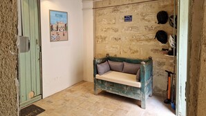 Una habitación con puerta verde, un banco, un cartel en la pared y un aparcamiento para bicicletas.