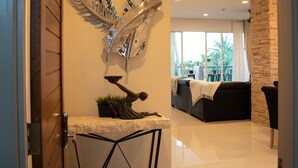A modern living room with a stone wall, a sofa, and a decorative metal piece on the wall. - Sunset Bliss Andaman Sea View (Klong Muang)