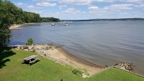 A lakeside view with boats, a picnic table, and a grassy area.