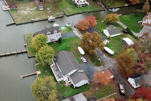 An aerial view of a residential area with houses, a dock, and a body of water.