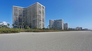 A beachfront hotel with multiple high-rise buildings, sandy beach, and clear blue sky. - Beachfront 2BR in South Seas T3-508 with Updated Kitchen! (Marco Island)
