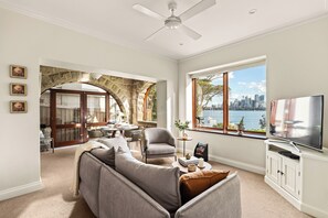 A living room with a large window, a television, and a fireplace.