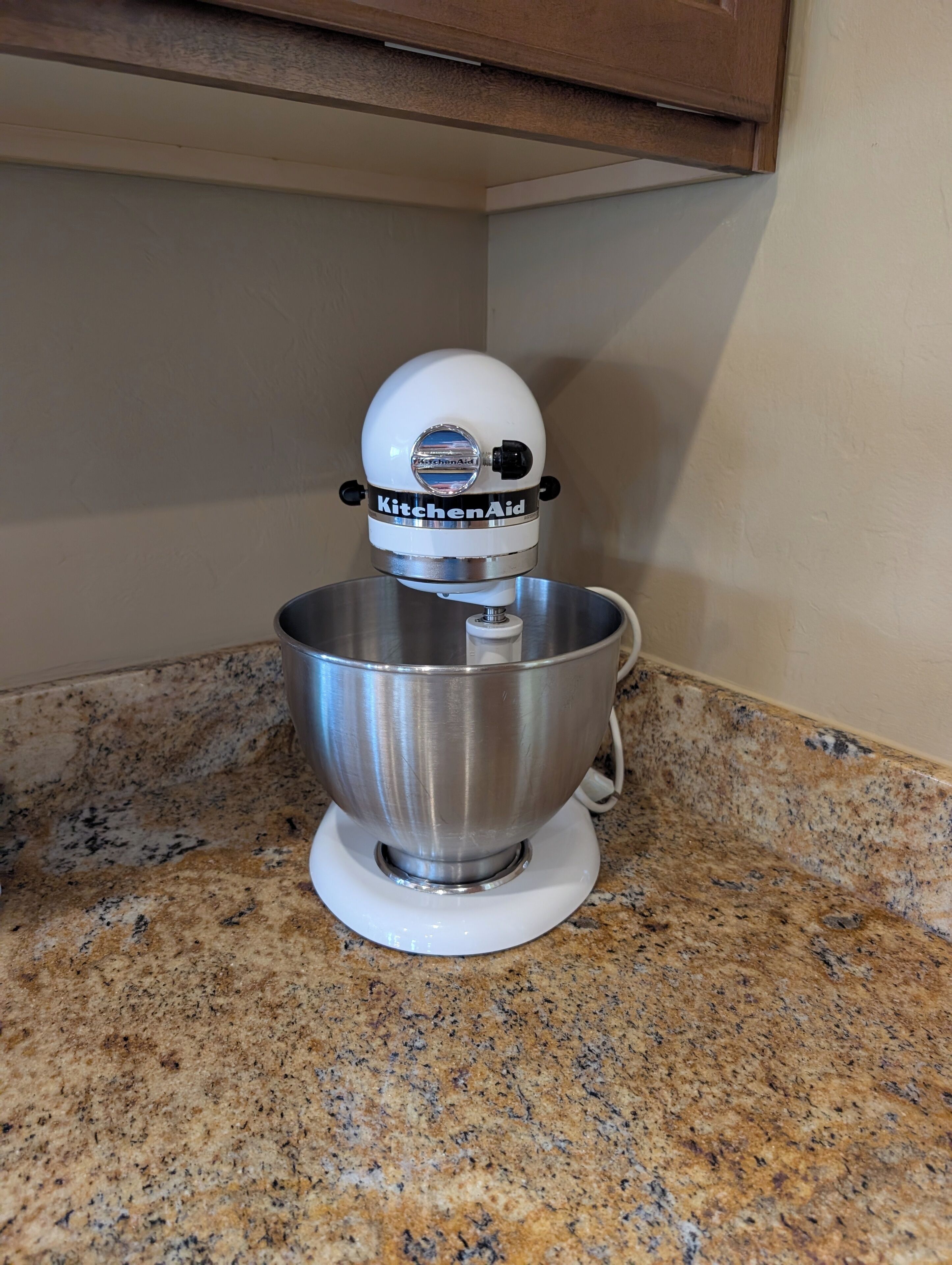 A KitchenAid stand mixer on a granite countertop.