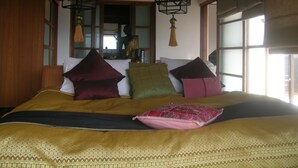 Een bed met meerdere kussens en een beddegoed met een patroon.