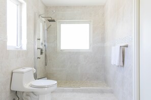 Een bad/douchecombinatie, een bubbelbad, een haardroger, een bidet