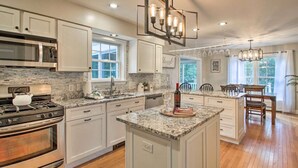 A kitchen with white cabinets, granite countertops, stainless steel appliances, and a central island. - Private & Super Spacious, close to downtown N. Conway and ski. (Conway)