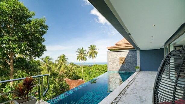 A balcony with a clear view of a swimming pool, surrounded by lush greenery and palm trees. - 3 Bedroom Sea View Villa Mattana 2 SDV162 - Chaweng Noi - By Samui Dream Villas (Koh Samui)