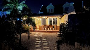 Una casa con patio, un camino de piedra y palmeras.
