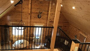 A wooden interior with a dining area, a staircase, and a ceiling with a skylight. - New Log Cabin On 3 Wooded Acres, Outdoor Shower, Lake Michigan,  Air-Conditioned (Mears)