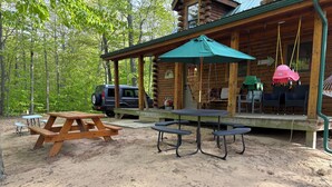A wooden cabin with picnic tables and a swing set. - New Log Cabin On 3 Wooded Acres, Outdoor Shower, Lake Michigan,  Air-Conditioned (Mears)