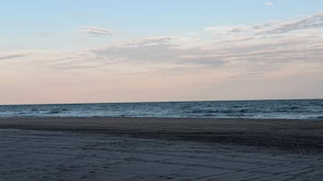 A beach with a clear sky and calm sea.