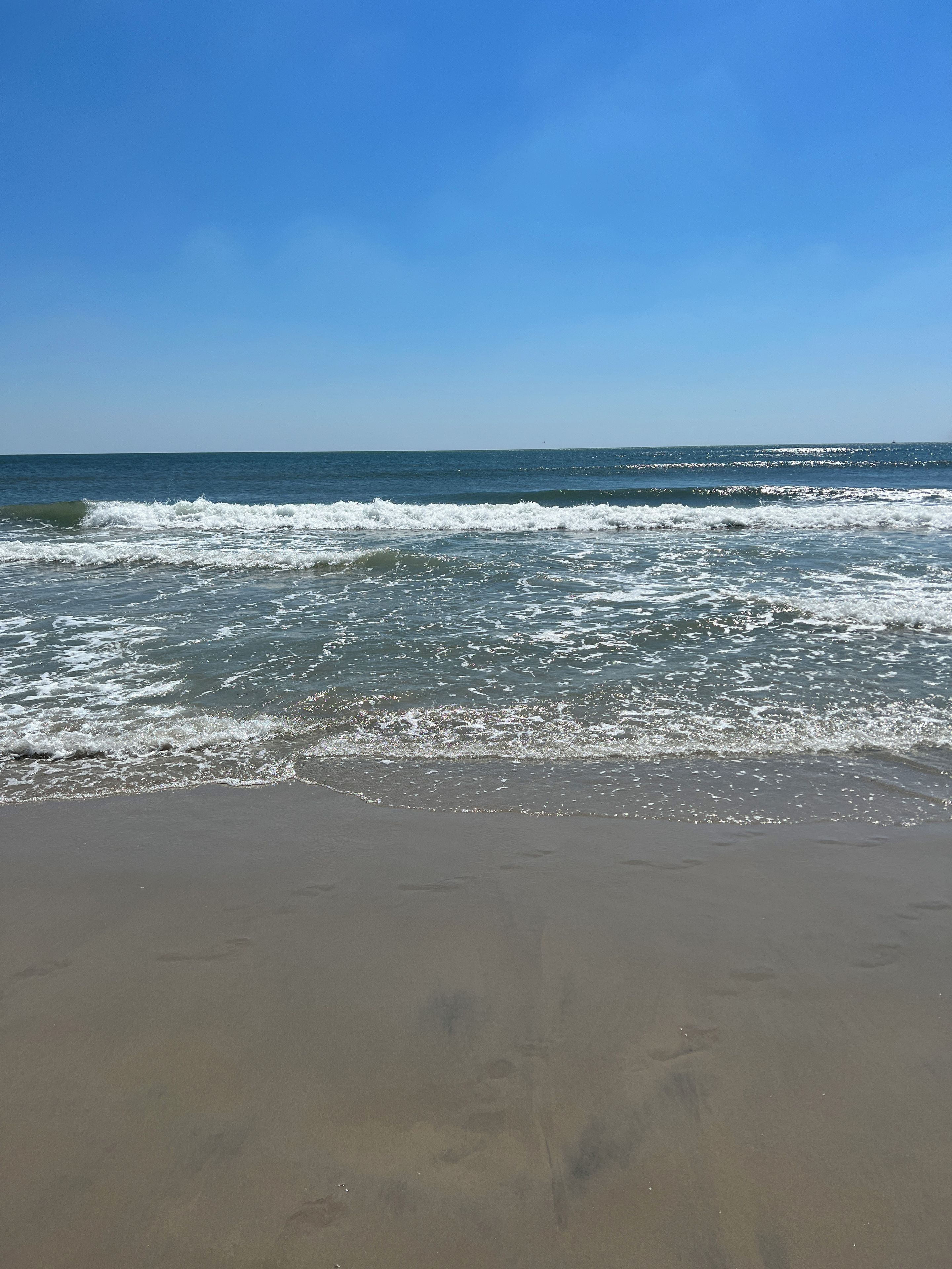 Een strand met golven die de kust naderen.