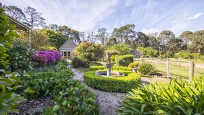 Ein Garten mit Gazebo, Springbrunnen und verschiedenen Pflanzen.