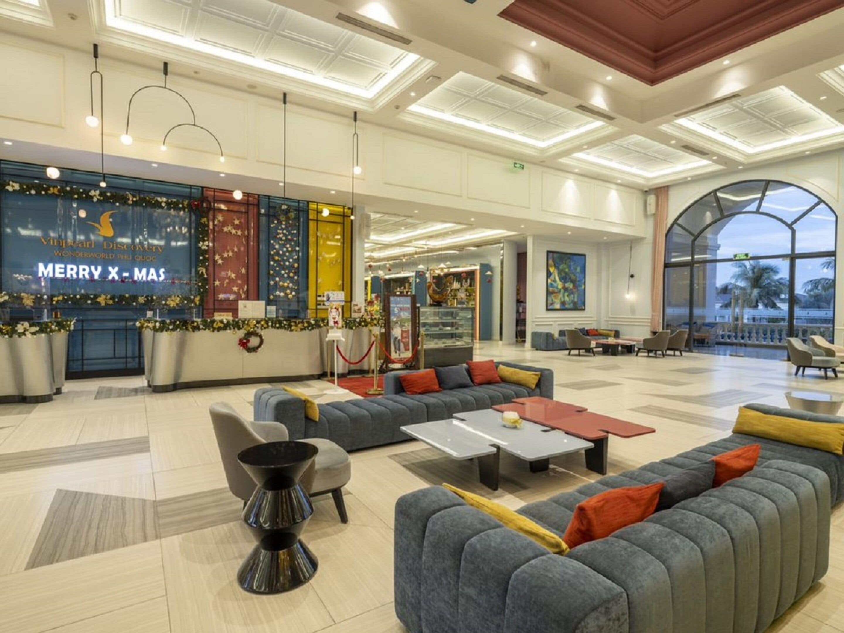 A spacious lobby with a seating area, a Christmas display, and a large window offering a view.