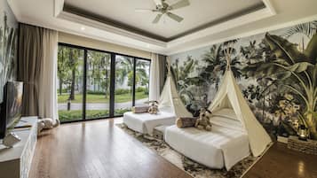 A spacious room with a large window, a ceiling fan, a mural of tropical foliage, and a tent-like bed structure.
