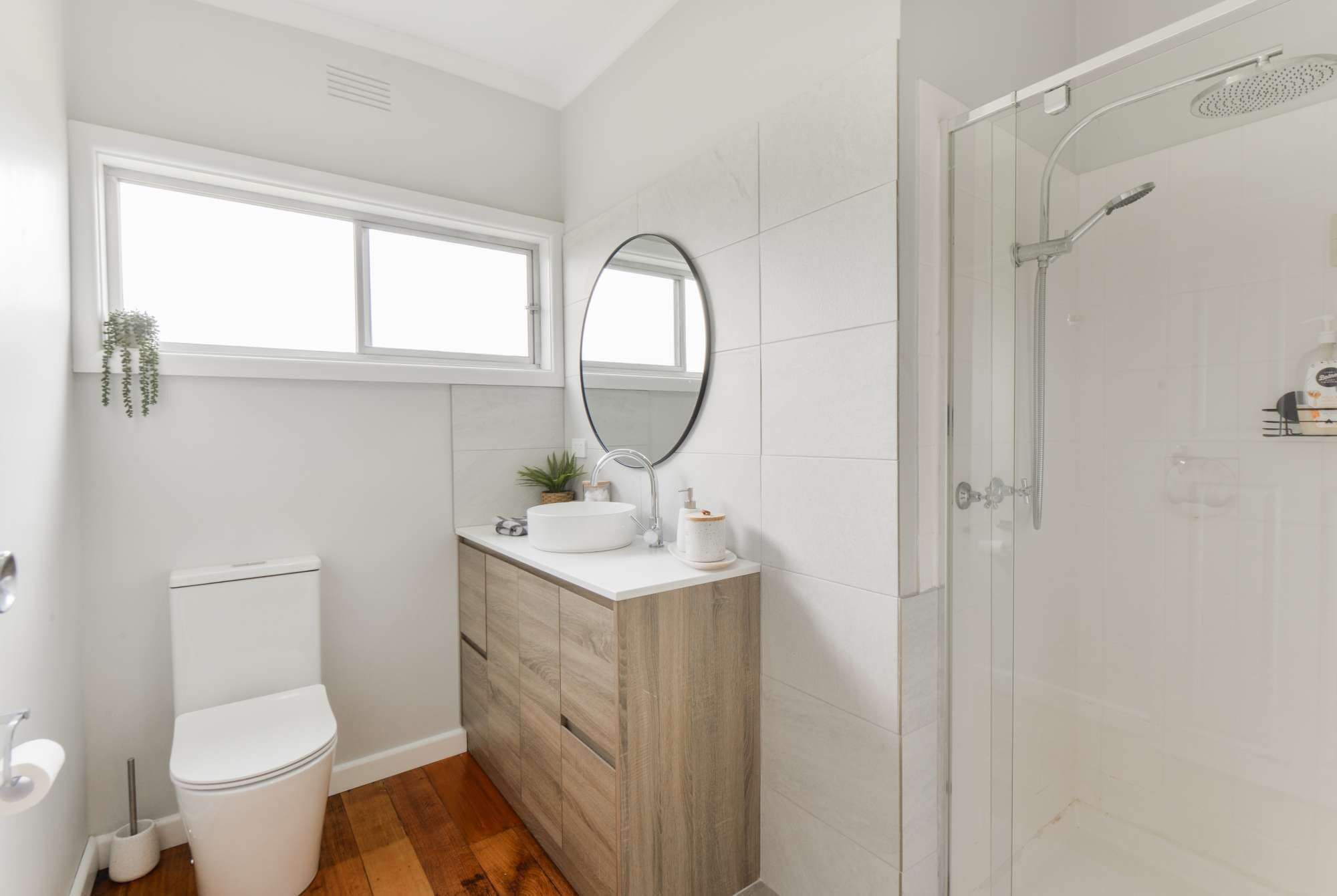 Un baño moderno con inodoro, tocador y ducha.