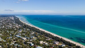 An aerial view of a coastal residential area with a beach, houses, and clear blue waters. - Pet Friendly - Bay Views From Drury Lane with Solar Heated Pool and Gas Heated Spa (Dromana)