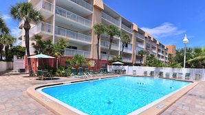 A swimming pool with clear blue water, surrounded by a tiled deck. - Direct Gulf Front Beach Paradise! Any Closer To The Water & You Would Be In It.. (Indian Shores)