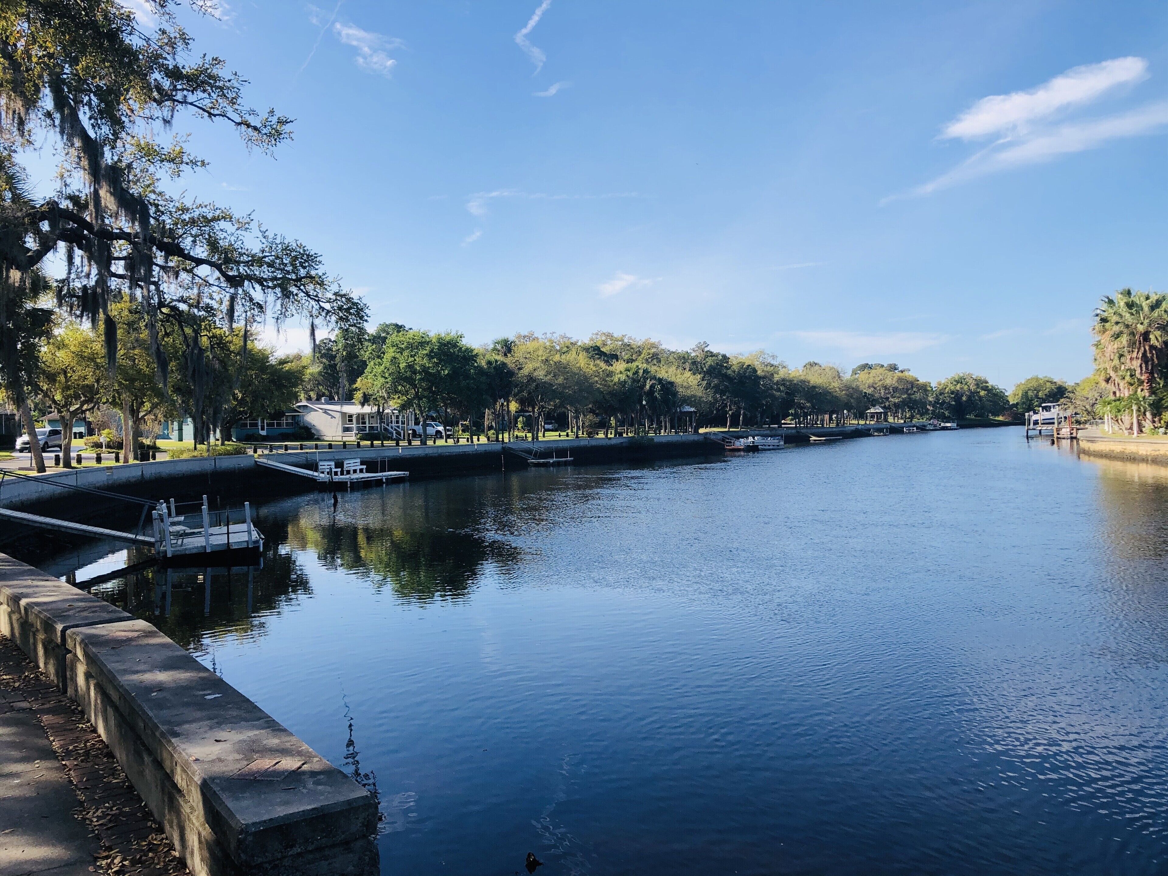 A calm river with a dock and a small boat.