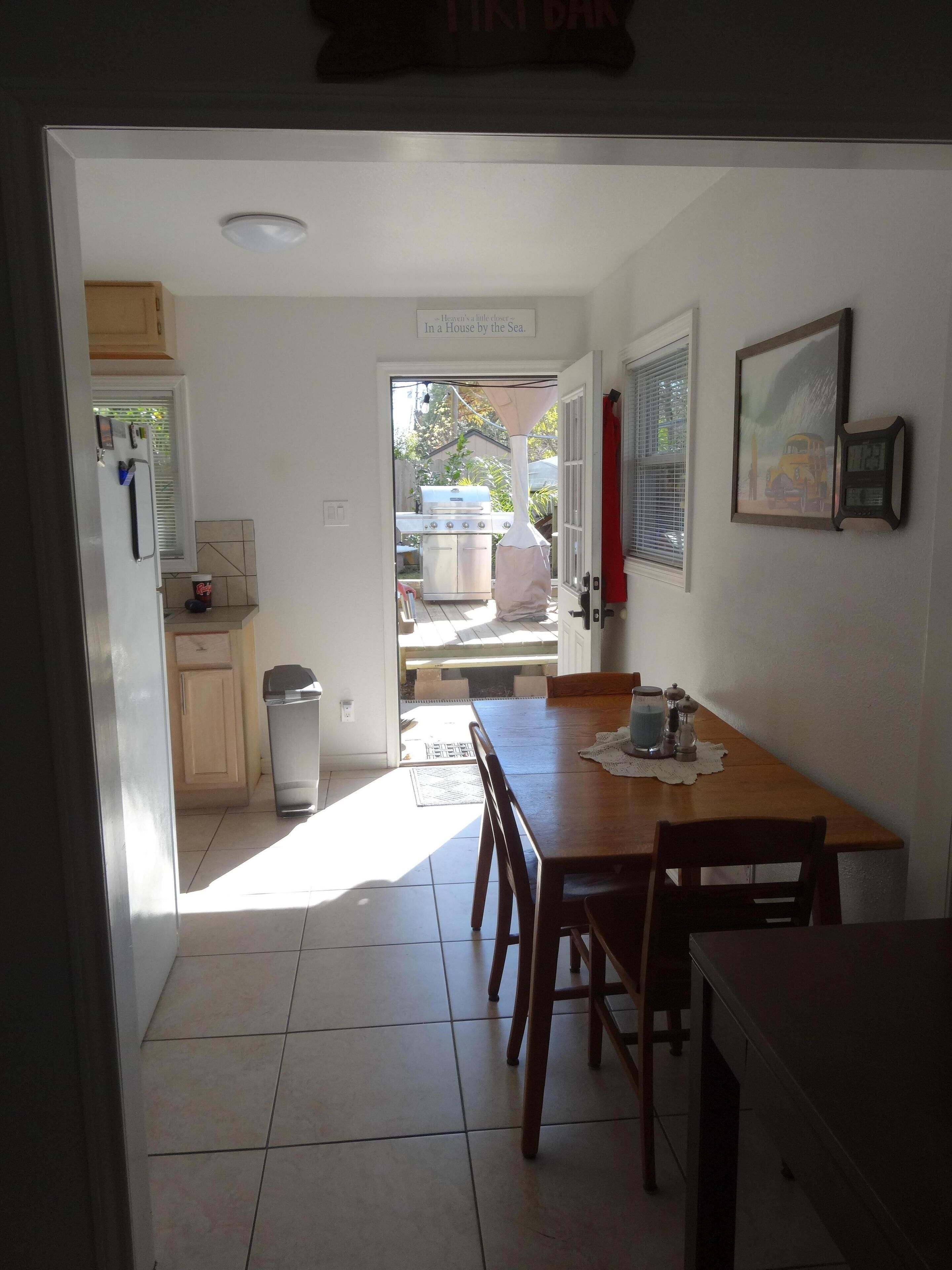 Une cuisine avec un coin repas, un barbecue et un tableau encadré au mur.