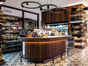 A cheese shop with a wooden counter and shelves stocked with various cheeses and bottles.