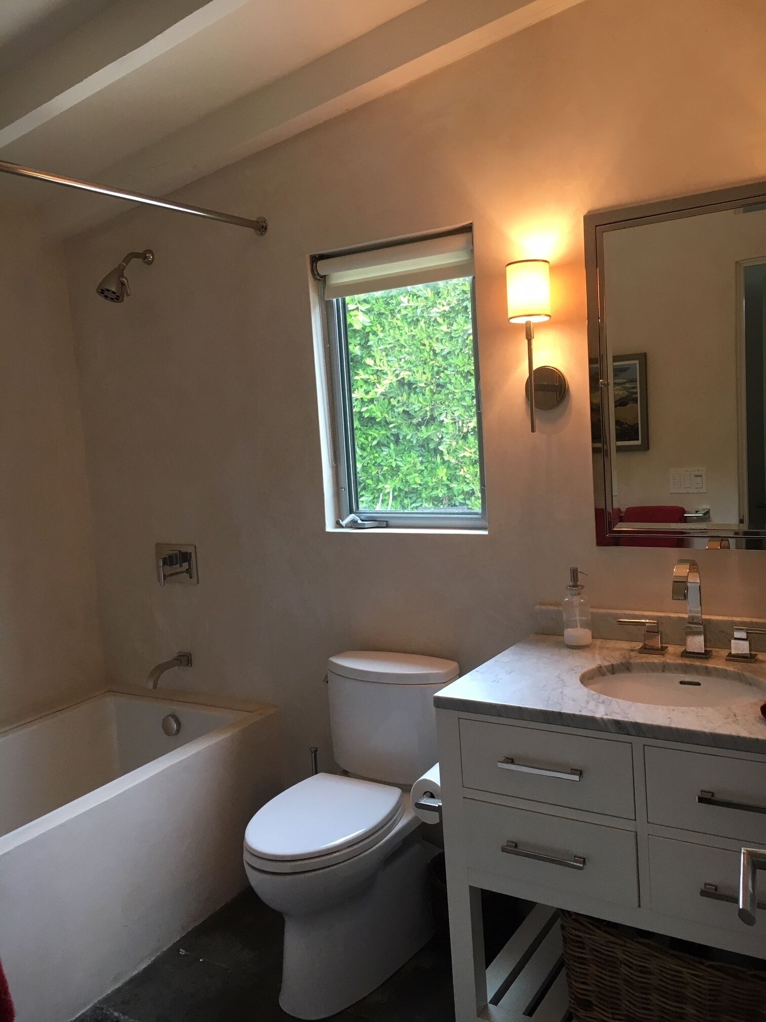 A bathroom with a bathtub, toilet, and sink.