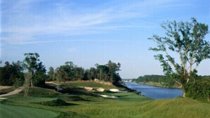 A golf course with a water body and trees. - BEAUTIFUL 2BR condo;Norman Course, Barefoot Resort;top-rated beach! (North Myrtle Beach)