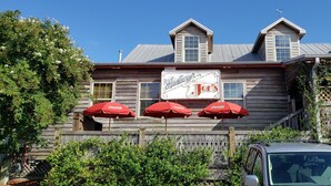 A wooden building with a sign reading "Hamburger Joe's" and three red umbrellas. - BEAUTIFUL 2BR condo;Norman Course, Barefoot Resort;top-rated beach! (North Myrtle Beach)