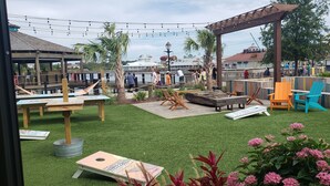 An outdoor patio area with artificial grass, wooden furniture, and a gazebo. - BEAUTIFUL 2BR condo;Norman Course, Barefoot Resort;top-rated beach! (North Myrtle Beach)