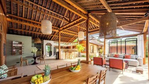 Un salón amplio con una mesa de comedor de madera, un sofá y un ventanal grande.