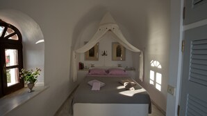 A bedroom with a bed, a window, and a vase of flowers. - Breathtaking view, luxury, privacy, style and much more ! (Firostefani)