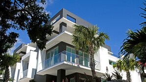 A modern multi-story building with balconies and large windows.