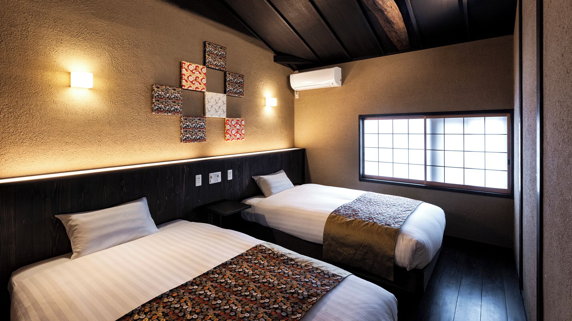 Quarto de hotel com duas camas, janela com vista e decoração de parede.