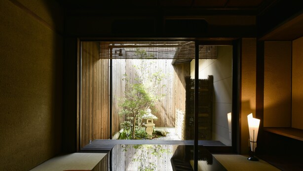 A traditional Japanese room with tatami flooring, a shoji screen, and a small garden view. - Rinn Premium Yae  (Kyoto)