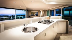 Una cocina moderna con una isla grande, un lavamanos de acero inoxidable y una estufa a gas.