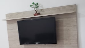 Una sala moderna con un televisor de pantalla plana instalado en un mueble de pared de madera.