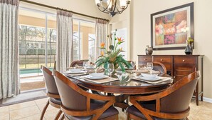 Comedor con mesa de vidrio, sillas, candelabro y juego de comedor.