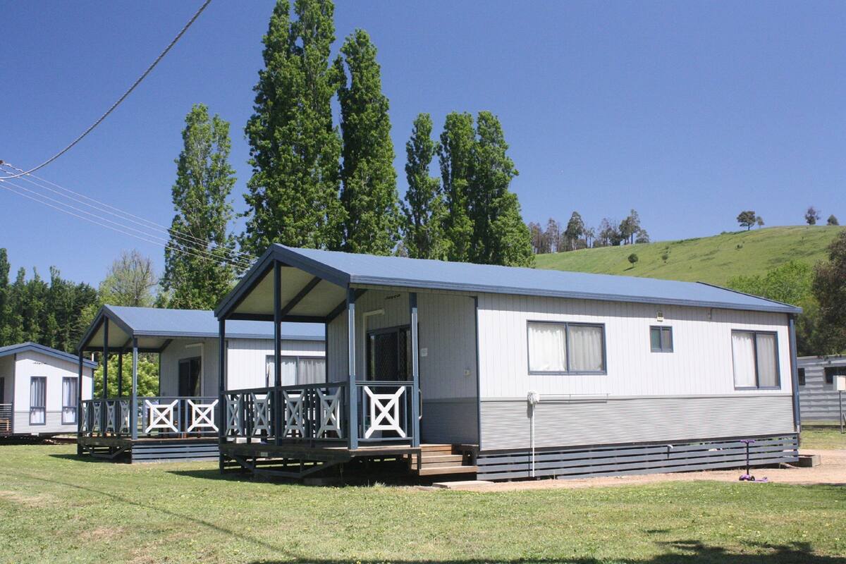 A single-story mobile home with a porch and a covered deck area.