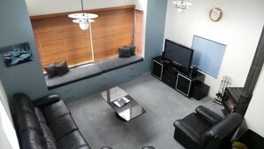 A modern living room with a sofa set, a coffee table, a TV, and a fireplace.