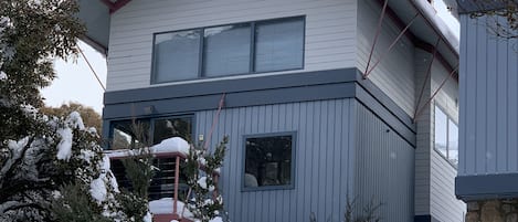 A two-story house with a stone foundation and a white exterior.