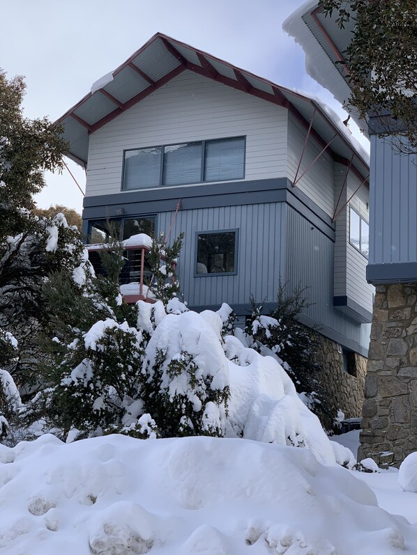 A two-story house with a stone foundation and a white exterior.