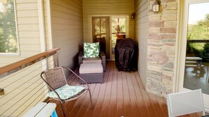 A covered porch with wicker furniture, a stone wall, and a view of the outdoors. - Spacious 3 bed/2 bath Condo closest to Bridges Bay Amenities (Okoboji)