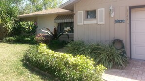 A residential house with a beige exterior, a front door, and a small window with shutters.