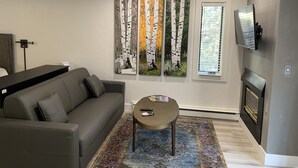 A modern living room with a grey sofa, a coffee table, and a large window with blinds. - 1 min. walk to Ski Lift/Gondola, shopping & dining! Perfect location!New Remodel (Vail)