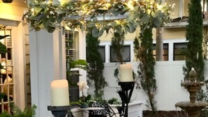 An outdoor dining area with tables set for two, featuring clear glassware and white plates. - Location, Location, Location!  Carriage House in Historic Old NE District (St. Petersburg)