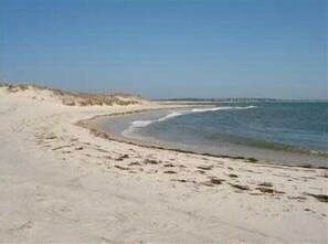 A sandy beach with gentle waves and a clear sky.