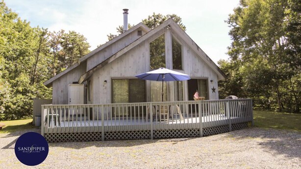 Eine Holzhütte mit einer Veranda und einem Schornstein.