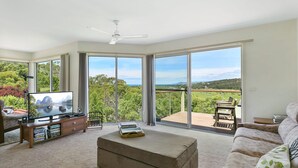 A spacious living room with a large flat-screen TV, a wooden coffee table, and a sofa. - Panoramic Views (Aireys Inlet)