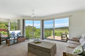 A spacious living room with a large flat-screen TV, a wooden coffee table, and a sofa. - Panoramic Views (Aireys Inlet)